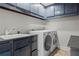Laundry room featuring blue cabinets, a sink and washer and dryer machines at 1890 Spalding Dr, Atlanta, GA 30350