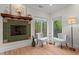 Cozy sitting area with fireplace and two chairs next to large windows with lots of natural light at 1890 Spalding Dr, Atlanta, GA 30350