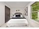 Well-decorated bedroom with stylish decor, a comfortable bed, and large window with greenery view at 244 Birch St, Atlanta, GA 30354