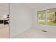 Bright bedroom featuring neutral carpet, a view to the outside, and white walls at 244 Birch St, Atlanta, GA 30354
