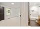 Bright bedroom with white carpet, a window and a dark door leading into a bathroom with grey tile floors at 244 Birch St, Atlanta, GA 30354