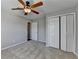 Neutral bedroom featuring plush carpet, a ceiling fan, and a closet with folding doors at 3938 Stillwater Dr, Duluth, GA 30096