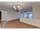 Dining area with views of the living room, hardwood floors, decorative trim, and chandelier at 3938 Stillwater Dr, Duluth, GA 30096