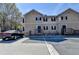 Exterior view of the townhome featuring neutral colors, black shutters, and a car parked in front at 3938 Stillwater Dr, Duluth, GA 30096