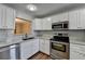Modern kitchen featuring white cabinets, stainless steel appliances, and subway tile backsplash at 3938 Stillwater Dr, Duluth, GA 30096