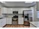 Modern kitchen featuring white cabinets, stainless steel appliances, and granite countertops at 3938 Stillwater Dr, Duluth, GA 30096