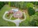 Estate featuring a beautiful pool and circular driveway surrounded by mature trees and landscaping at 5040 Fawn Valley Dr, Loganville, GA 30052