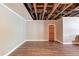 Basement features exposed ceiling, vinyl flooring, neutral walls, and a door to another room at 5040 Fawn Valley Dr, Loganville, GA 30052