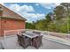 Outdoor deck area featuring a dining table and chairs with a view of the pool and surrounding trees at 5040 Fawn Valley Dr, Loganville, GA 30052