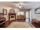 Cozy living room with fireplace, hardwood floors, and comfortable seating, perfect for relaxation at 5040 Fawn Valley Dr, Loganville, GA 30052