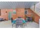 Covered patio area featuring an outdoor dining setup and exposed brick wall at 5040 Fawn Valley Dr, Loganville, GA 30052