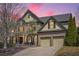 Beautiful brick home featuring an attached garage, mature trees, and manicured landscaping at dusk at 4030 Gold Mill Rdg, Canton, GA 30114