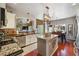 Open-concept kitchen boasts a granite island, stainless steel appliances, and dark wood flooring at 4030 Gold Mill Rdg, Canton, GA 30114