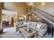 Bright living room featuring a staircase, large sectional sofa, and a view into the dining room and kitchen at 4030 Gold Mill Rdg, Canton, GA 30114