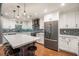Modern kitchen features white cabinetry, stainless appliances, island with seating, and stone backsplash at 708 Mcgill Ne Pl, Atlanta, GA 30312