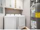 Laundry room with washer, dryer, cabinet and energy-efficient water heater at 708 Mcgill Ne Pl, Atlanta, GA 30312