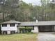 Charming home with a well-maintained lawn, mature trees, and a functional carport at 2414 West Rd, Riverdale, GA 30296