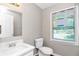 Bathroom with vanity, toilet, and large window, offering bright natural light at 3052 Sw Highbury Sw Trl, Atlanta, GA 30354