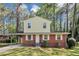 Charming two-story home features a brick facade, light yellow siding, and a covered carport in a lush, green setting at 3052 Sw Highbury Sw Trl, Atlanta, GA 30354