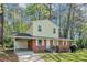 Charming two-story home features a brick facade, light yellow siding, and a covered carport in a lush, green setting at 3052 Sw Highbury Sw Trl, Atlanta, GA 30354
