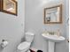 Neutral powder room with a pedestal sink, framed mirror and toilet in a well-lit space at 3117 Dogwood Dr, Hapeville, GA 30354