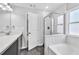 Bright bathroom with updated double vanity, framed mirror, and a combined tub and shower with glass doors at 3117 Dogwood Dr, Hapeville, GA 30354