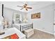 This bedroom features carpet, a window, and a ceiling fan above the bed with white bedding at 3117 Dogwood Dr, Hapeville, GA 30354