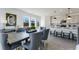 An open concept dining room boasts views from multiple windows, wood floors and gray modern decor at 93 Wilder Ridge Way, Lawrenceville, GA 30044