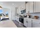 A kitchen with a black sink and faucet, stainless steel appliances, white cabinets and quartz countertops at 93 Wilder Ridge Way, Lawrenceville, GA 30044