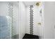 Modern bathroom features a glass enclosed shower with black and white geometric tile accents at 1251 Pierce Se Ave, Smyrna, GA 30080