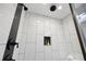 Modern walk-in shower featuring sleek fixtures, tiled walls, and recessed niche at 1251 Pierce Se Ave, Smyrna, GA 30080