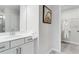 Well-lit bathroom featuring vanity with drawers and a framed mirror next to open closet with a white robe at 300 Oldvine Dr, Lawrenceville, GA 30044