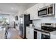 Modern kitchen with stainless steel appliances, a subway tile backsplash, and an adjacent living area at 300 Oldvine Dr, Lawrenceville, GA 30044