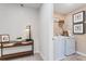 Modern laundry room with white washer and dryer with folding shelf, plus decor lamp near a dark wood shelf at 300 Oldvine Dr, Lawrenceville, GA 30044
