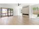 Spacious living room with hardwood floors, a ceiling fan, a stone fireplace, and double doors to a patio at 504 Barrington Dr, Roswell, GA 30075