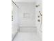 Elegant bathroom shower with white marble tiles, gold fixtures, a shower bench, and a glass enclosure at 504 Barrington Dr, Roswell, GA 30075