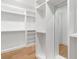 Spacious walk-in closet with built-in shelving, wood floor and a full-length mirror at 504 Barrington Dr, Roswell, GA 30075