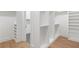 Large walk-in closet with custom shelves, hardwood floors, and access to another room at 504 Barrington Dr, Roswell, GA 30075