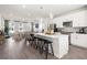 Open-concept kitchen with island, stainless steel appliances, and seating overlooking a comfortable living area at 524 Provence Gate Ln, Lawrenceville, GA 30044