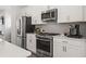 Modern kitchen featuring stainless steel appliances, white cabinets, and sleek countertops at 524 Provence Gate Ln, Lawrenceville, GA 30044