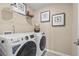 Modern laundry room with new front-load washer and dryer, shelving, and framed artwork at 524 Provence Gate Ln, Lawrenceville, GA 30044