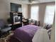 Bedroom with two windows, carpet, a double bed with blanket, a baby play pen, and a TV at 1074 Deshon Trl, Lithonia, GA 30058