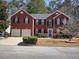 Charming brick home featuring a well-manicured lawn, two-car garage, and inviting front entrance at 1074 Deshon Trl, Lithonia, GA 30058