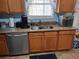 Kitchen features stainless steel dishwasher, double sink, granite countertops, and wooden cabinetry at 1074 Deshon Trl, Lithonia, GA 30058