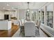 Bright dining room features a long table, chandelier, and large windows overlooking the wooded backyard at 2283 Edgemere Lake Cir, Marietta, GA 30062