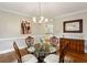 Formal dining room with a glass-top table, classic chandelier, and hardwood floors at 2283 Edgemere Lake Cir, Marietta, GA 30062