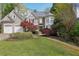 Charming two-story home featuring a three-car garage, stone accents, and lush landscaping at 2283 Edgemere Lake Cir, Marietta, GA 30062