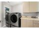 Functional laundry room with modern washer, dryer, cabinets, and sink at 2283 Edgemere Lake Cir, Marietta, GA 30062