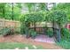 Beautiful backyard garden sitting area with rose bushes and a vine-covered pergola at 29 Fern Leaf Ct, Dallas, GA 30157