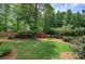 Expansive backyard featuring a vibrant lawn, mature trees, and a charming storage shed at 29 Fern Leaf Ct, Dallas, GA 30157